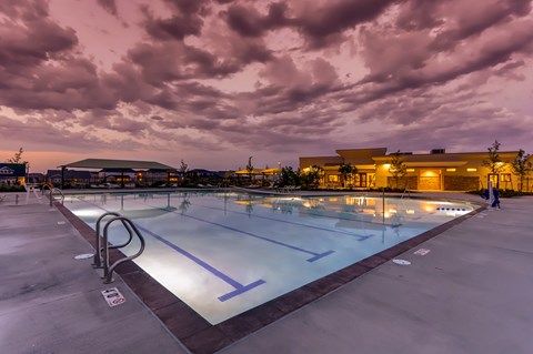 A large outdoor swimming pool with a building in the background.