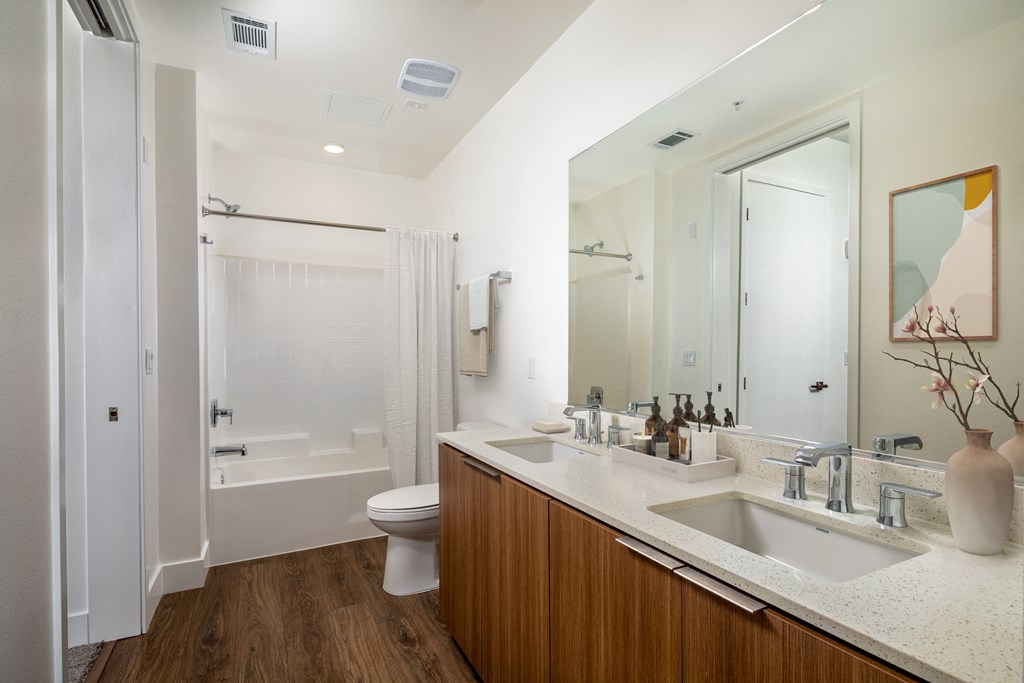 a bathroom with white walls and a wooden floor