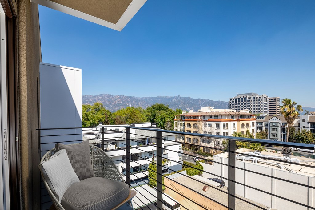 a balcony with a chair and a view of the city