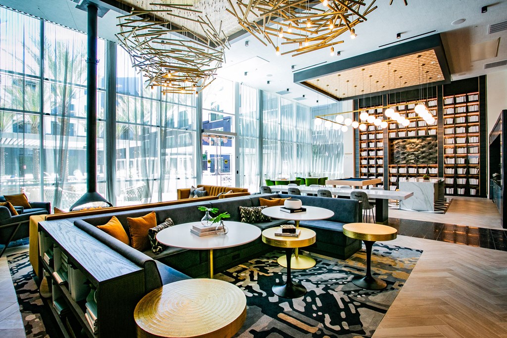 A view of lounge sitting area large window yellow couches light fixture.