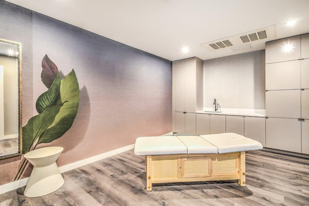 a room with a massage table and a stool