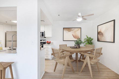 a dining room with a wooden table and chairs and a kitchen