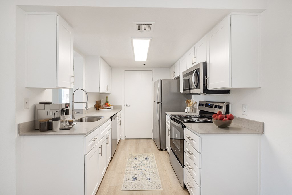 a kitchen with white cabinets and stainless steel appliances