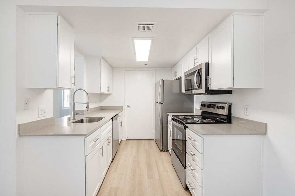 a kitchen with white cabinets and stainless steel appliances