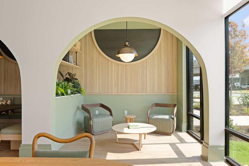 A modern living room with a wooden chair and a round table.