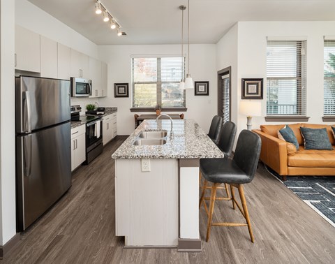 A modern kitchen with a large island and a refrigerator.