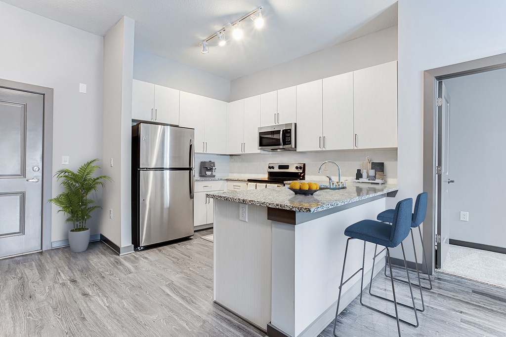 a kitchen with white cabinets and a large island with granite countertops