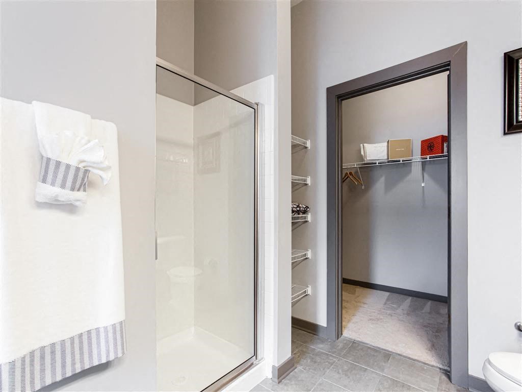 a bathroom with a walk in shower next to a toilet