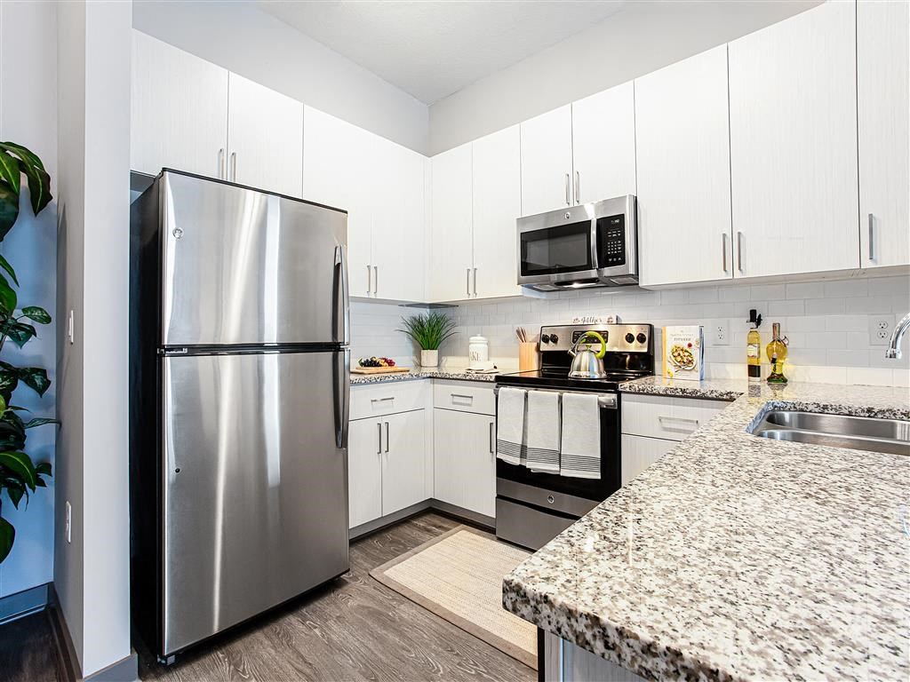 a kitchen with white cabinets and a stainless steel refrigerator