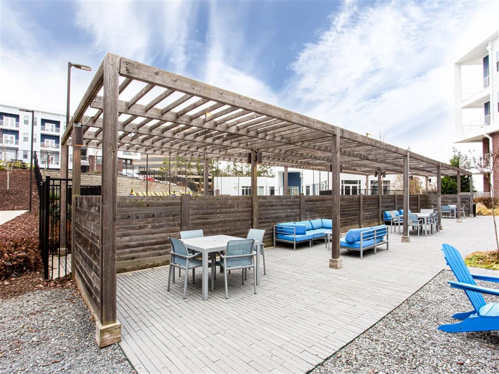 a patio with a pergola and tables and chairs