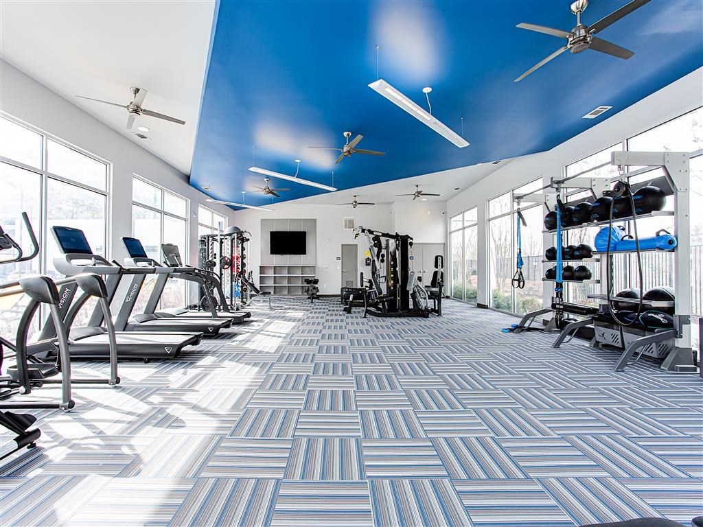 a spacious fitness center with treadmills and other exercise equipment