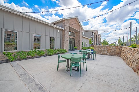 a patio with tables and chairs outside of a building