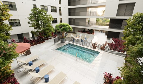 A pool surrounded by lounge chairs and trees.