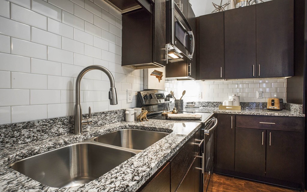 A kitchen with a sink and a microwave.
