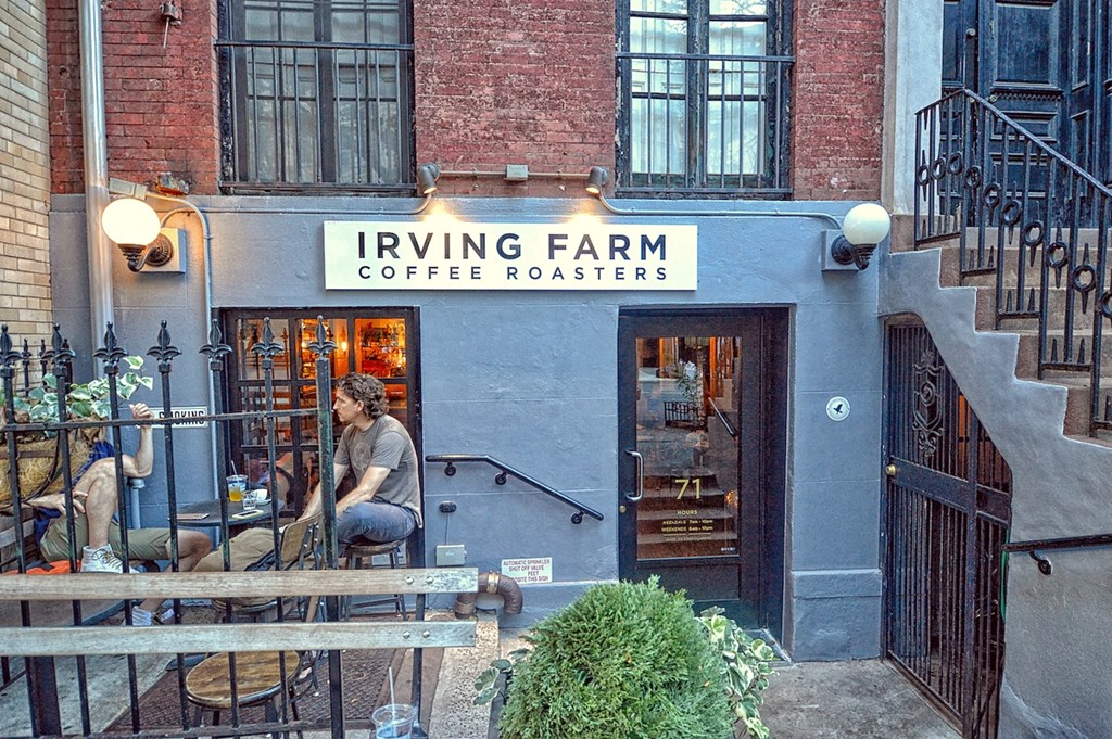 a woman sitting in front of a coffee shop