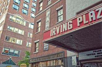 a photo of the riving plaza sign in front of a brick building