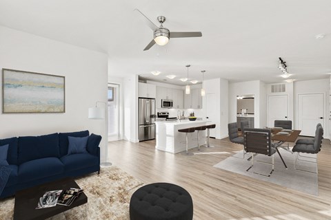 a living room with a blue couch and a kitchen with a table and chairs