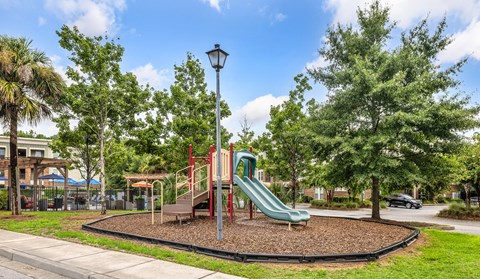 A playground with a green slide and a red and yellow structure.