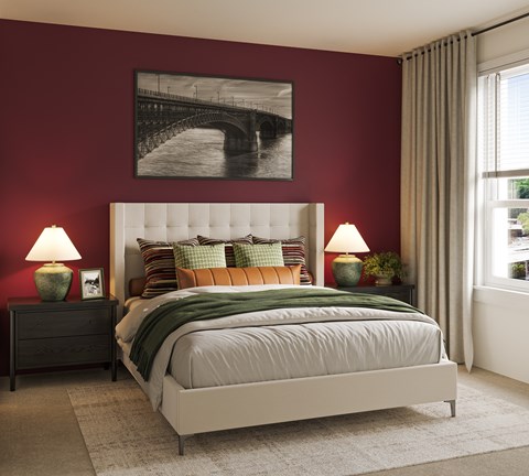 A bedroom with a large bed and a framed picture of a bridge above it.