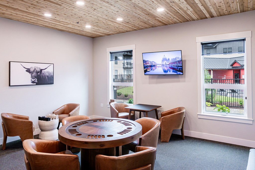 a round table with chairs in a room with two windows at The Farmstead, Washington