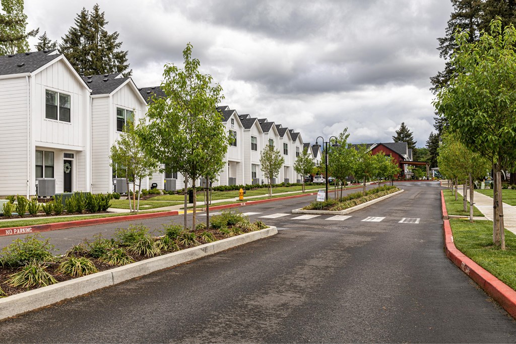 a street with white houses on the side of a road at The Farmstead, Vancouver
