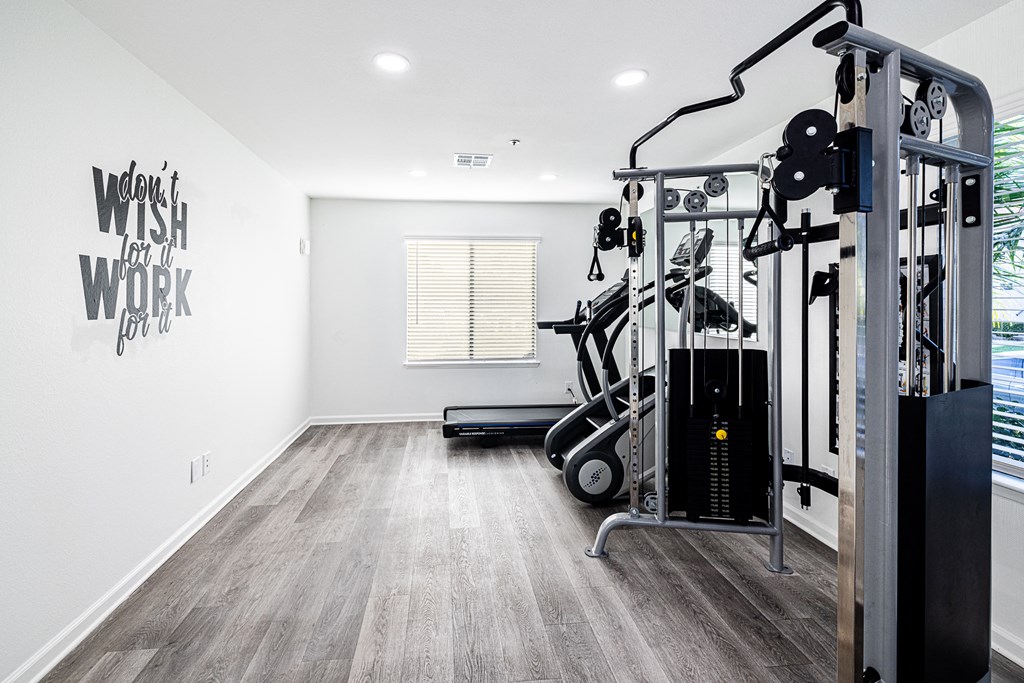 a home gym with exercise equipment and a window