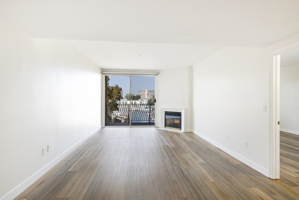A room with a fireplace and a view of a city through a window.
