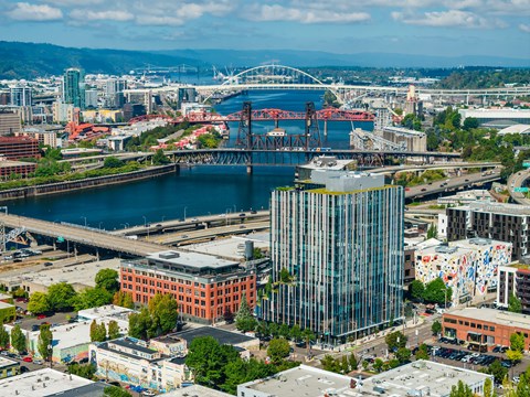 A cityscape with a large body of water and a bridge in the background.