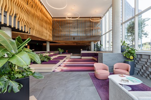 A modern interior with a wooden wall and a purple carpet.