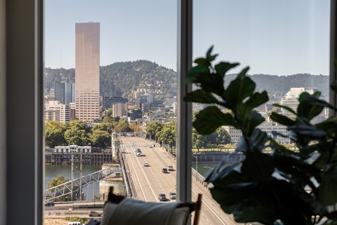 A view of a highway with a tall building in the distance.