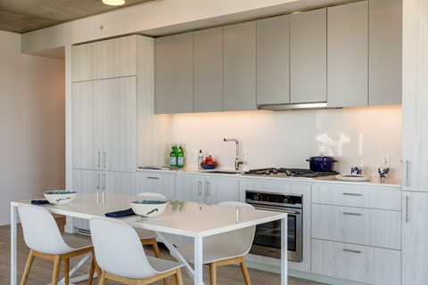 A modern kitchen with a white table and chairs.