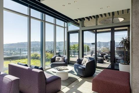 A modern living room with purple chairs and a view of the city.