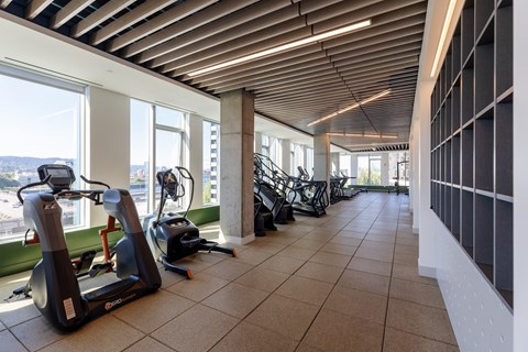 A gym with exercise equipment and a view of the city.