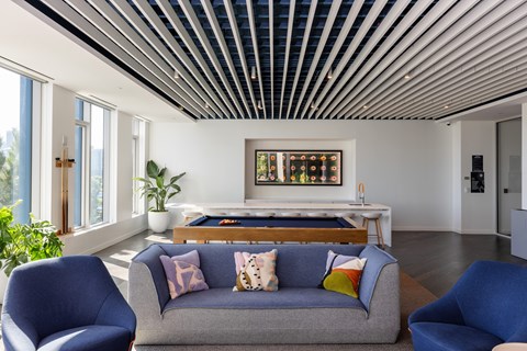 A living room with a grey couch and blue chairs.