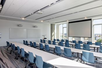 A conference room with a long table and chairs.