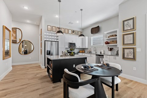 A modern kitchen with a black table and chairs.