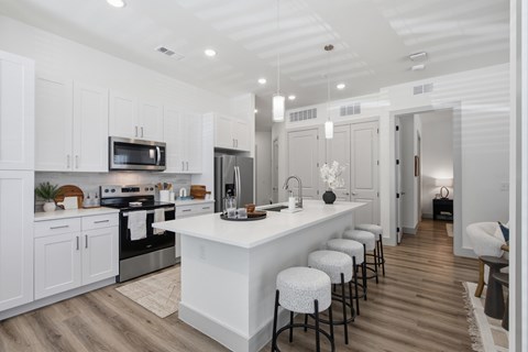 A modern kitchen with white cabinets and a central island.