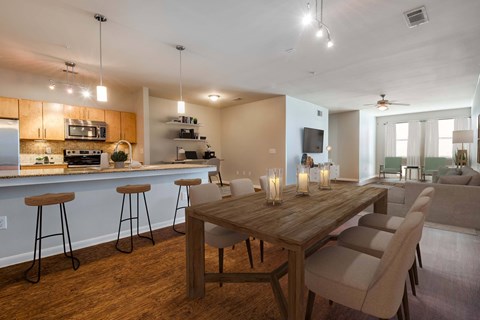 A modern kitchen with a bar area and a dining table with chairs.