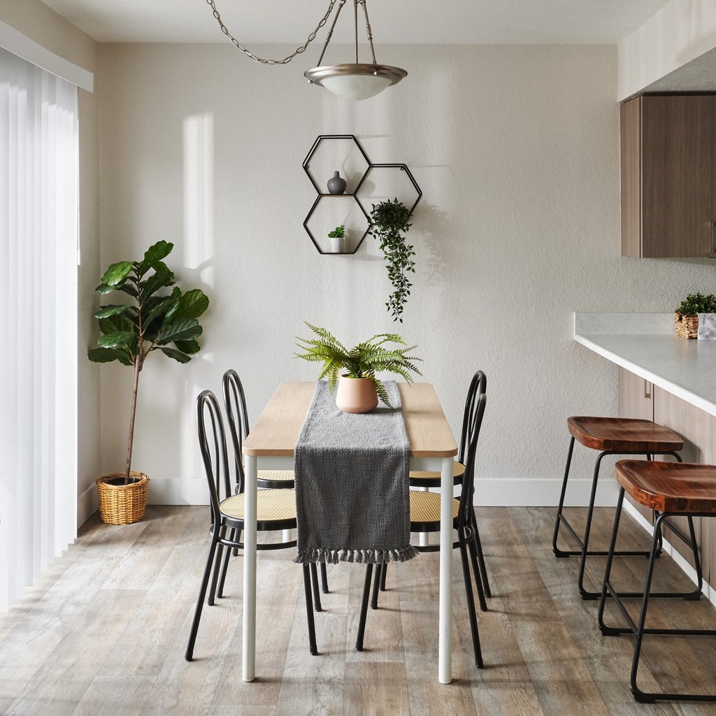 a dining area with a wooden table and black and white chairs