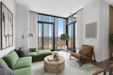 A living room with a green couch and a brown chair.