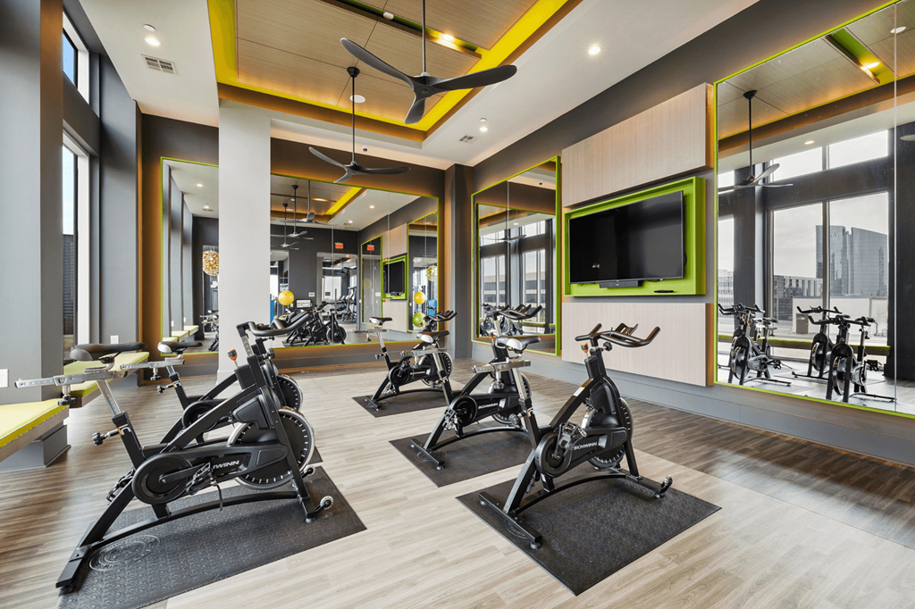 A gym with exercise bikes and a television.