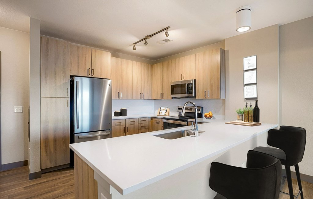 Virtually staged kitchen with light wood cabinets  at Novus, Lone Tree