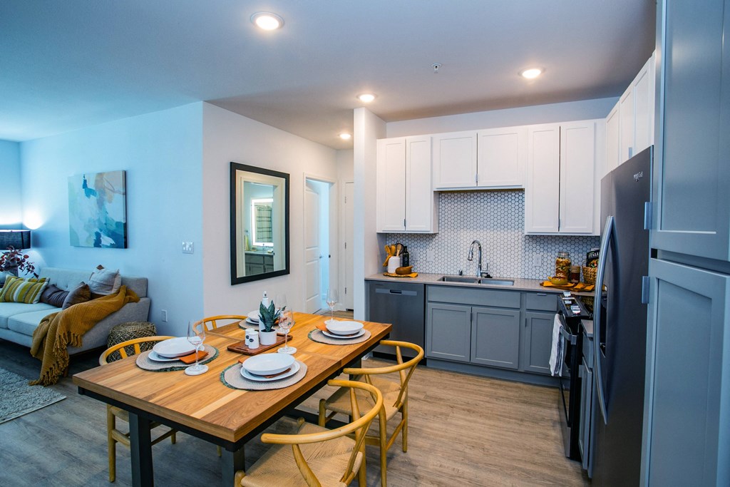 a kitchen and dining area with a wooden table and chairs