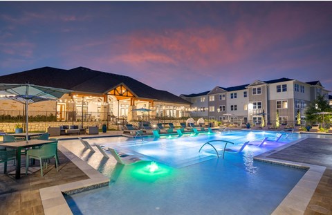 a swimming pool at night at an apartment complex