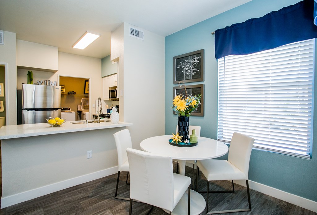 A kitchen with a table and chairs.