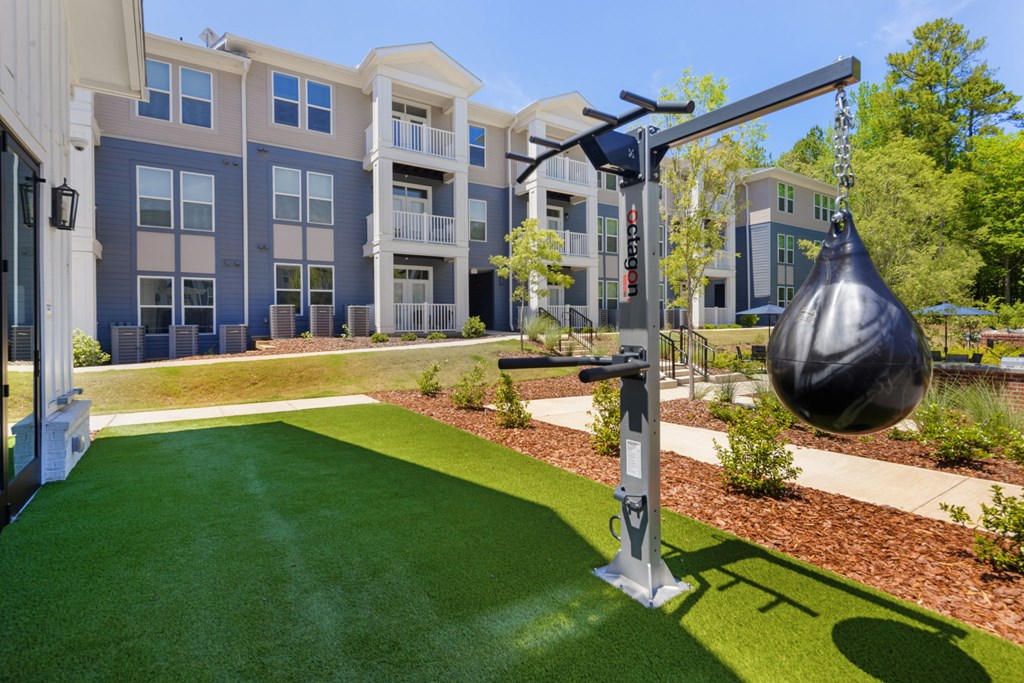 A playground with a swing set in front of apartment buildings.