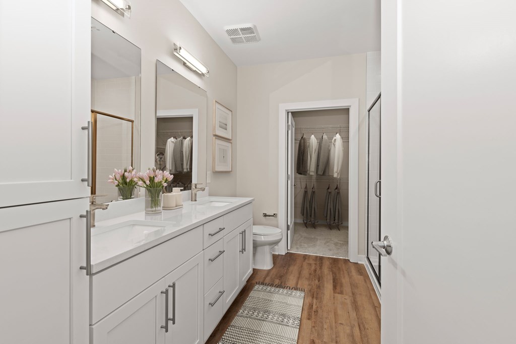 A white bathroom with a towel rack and a mirror.