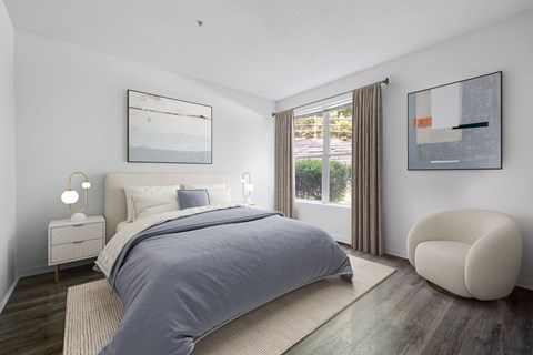 A bedroom with a large bed and a chair.