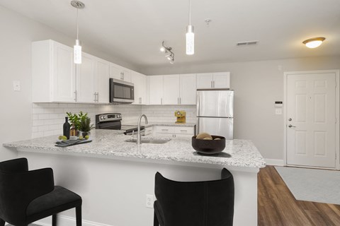 a kitchen with white cabinets and a granite counter top