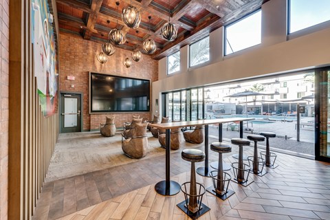 A row of bar stools are arranged in front of a television.